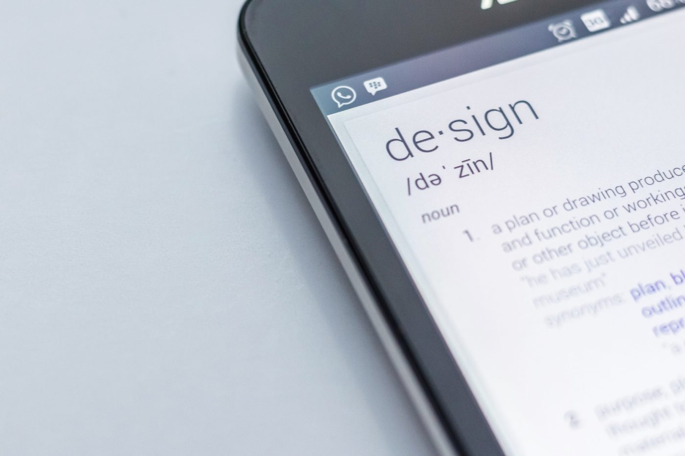 A phone displaying the definition of the word "Design".