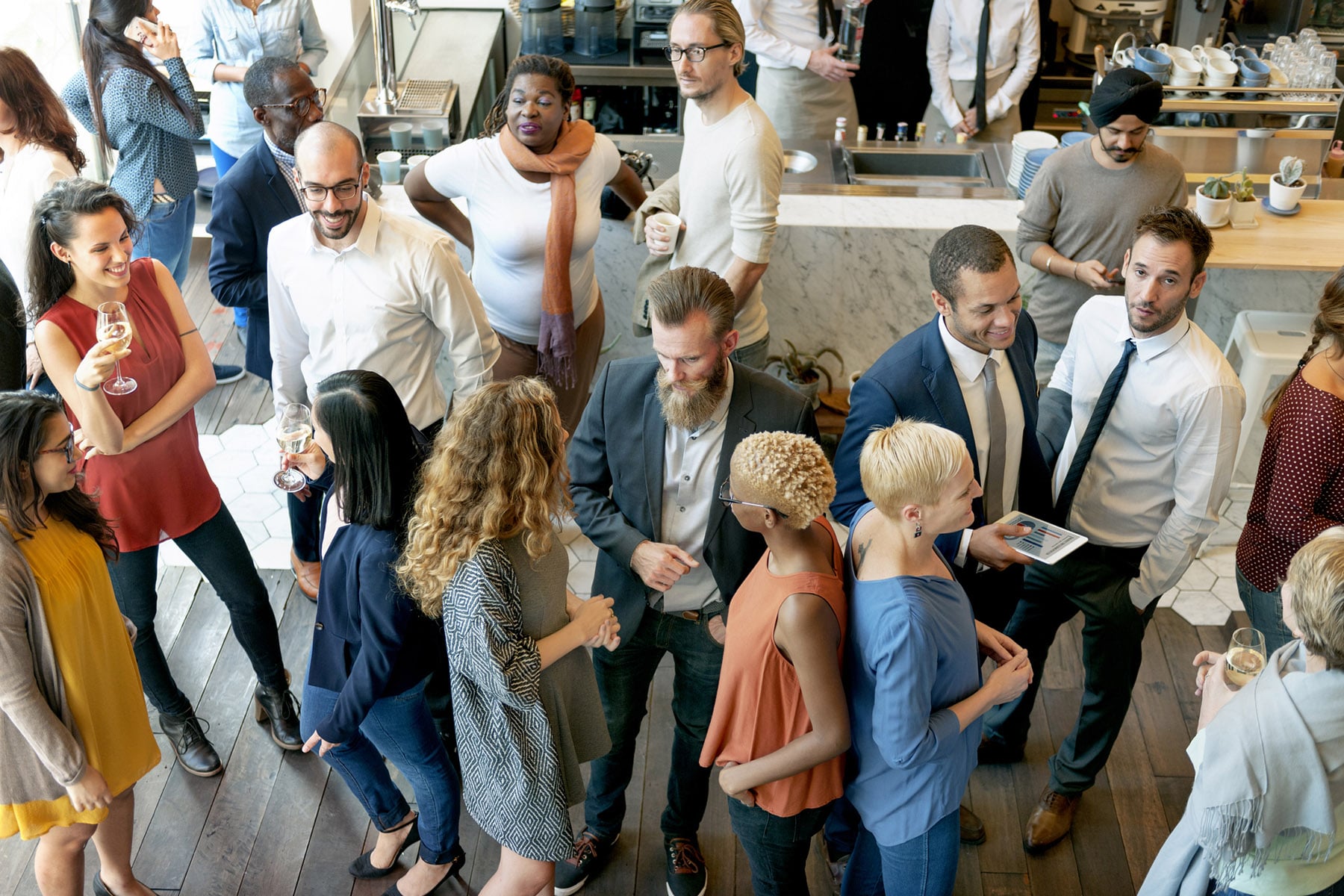  A group of diverse professionals networking and socializing in a casual setting.
